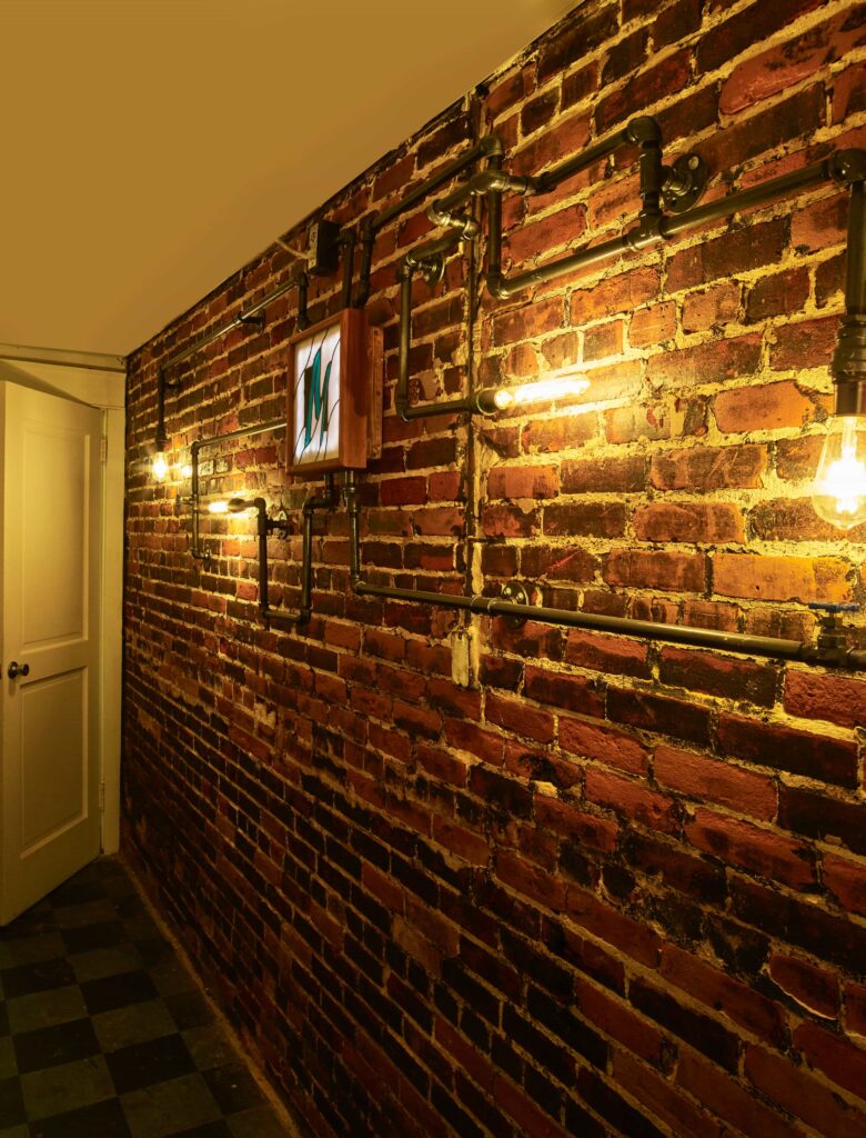 Brick wall with Edison lights and Morrisound logo in stained glass